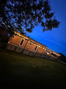 a house with lights on the side of it at night at Tracey’s Hideaway - with hot tub & amazing views in Llanasa