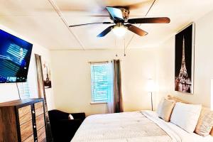 een slaapkamer met een plafondventilator en een bed bij Gainesville GameDay Getaway 3/2 in Gainesville
