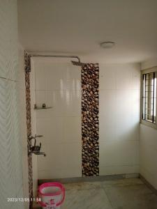 a bathroom with a shower and a wall of fire wood at LOZZY HOMESTAY in Guwahati