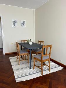 mesa de comedor con sillas y mesa negra en Departamento Caseros en Salta