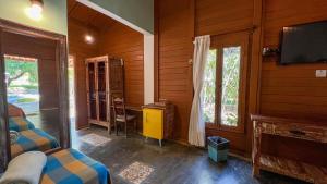 a bedroom with two beds and a tv and windows at Pousada Rancho da Serra in Martins