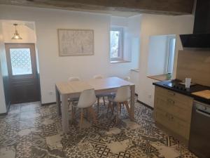 a kitchen with a table and chairs in a room at Gite blanche neige au pied du vercors in Hostun