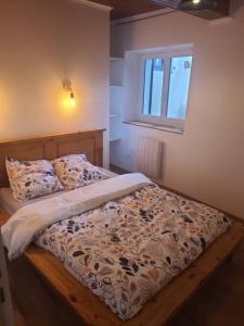 a bedroom with a bed with a comforter and a window at Gite blanche neige au pied du vercors in Hostun