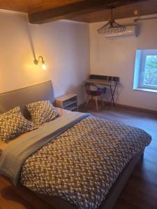 a bedroom with a bed and a desk in it at Gite blanche neige au pied du vercors in Hostun