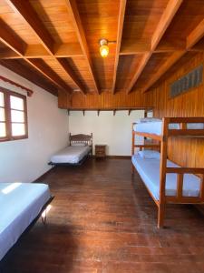 Habitación con 3 literas y techo de madera. en Inti Wasi en San Carlos
