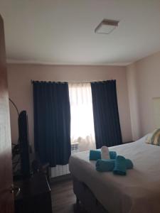 Un dormitorio con una cama con toallas azules. en LA LOMA AUSTRAL en El Calafate