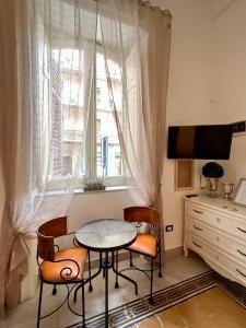 mesa y sillas en una habitación con ventana en Aristocasa B&B luxury rooms en Palermo
