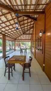 eine Terrasse mit einem Holztisch und Stühlen in der Unterkunft Pousada Rancho da Serra in Martins