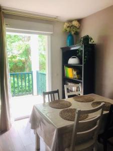 アングレットにあるAppartement T2 calme absolu, large terrasse, garage vélo, 5 min océanのダイニングルーム(テーブル、椅子、窓付) +11枚の写真