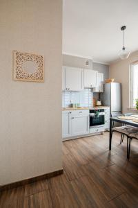 a kitchen with white cabinets and a table in a room at Ostróda Green Apartment in Ostróda