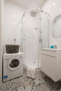a bathroom with a washing machine and a shower at Ostróda Green Apartment in Ostróda