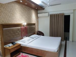 um quarto com uma cama e uma mesa de cabeceira e uma cama sidx sidx sidx em Hotel Red Roof Inn em Comilla