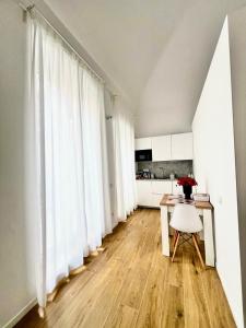 a room with white curtains and a table and a kitchen at Andrea's 12 in Bari