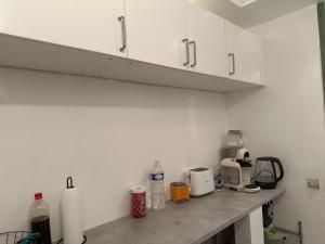 a kitchen with white cabinets and a counter top at DLTA Hote in Torcy