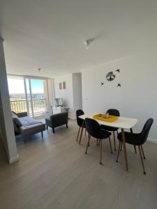 een woonkamer met een tafel en stoelen en een bank bij Hermoso y tranquilo departamento con estacionamiento in Puerto Montt