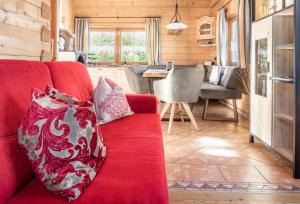a red couch in a living room with a table at Bergchalet am Tonimörtlhof in Mariapfarr