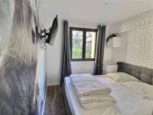 1 dormitorio con 1 cama con toallas en Chalet deS'AMY et sa terrasse pour 8/10 personnes, en Font-Romeu-Odeillo-Via