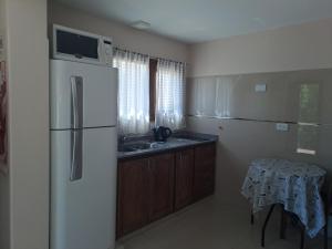 uma cozinha com um frigorífico, um lavatório e uma mesa em LA LOMA AUSTRAL em El Calafate