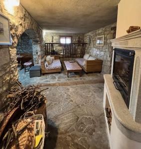 uma sala de estar com lareira e uma parede de pedra em I Ruderi di Maiano em Vaglia