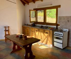 a kitchen with a stove and a table in it at Capri House in Lago Puelo