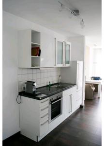 a white kitchen with a sink and a stove at Schönes Apartment im Dreiländereck in Bad Bellingen
