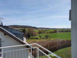 a balcony of a house with a view of a field at Schönes Apartment im Dreiländereck in Bad Bellingen