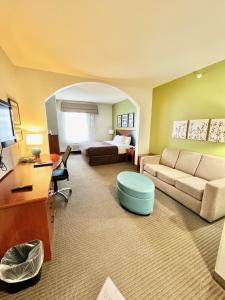 a large living room with a couch and a desk at Fort Stockton Inn and Suites in Fort Stockton