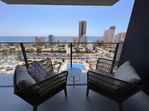 a balcony with chairs and a couch and a view of the ocean at Apartment-de-la-luz-calpe in Calpe