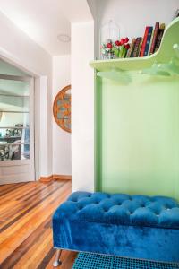 Habitaciones privadas en Ñuñoa في سانتياغو: أريكة بلاط زرقاء في غرفة مع رف