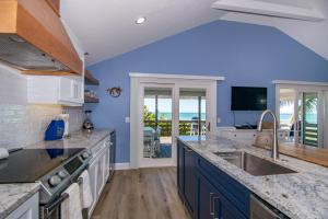 cocina con paredes azules y encimera grande en The Tiki House, en Holmes Beach