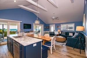 cocina y sala de estar con paredes azules en The Tiki House, en Holmes Beach
