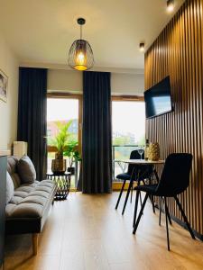 een woonkamer met een bank en een tafel bij Motlawa Inn Apartment-Suna,Gym&Parking in Gdańsk