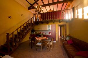 a living room with a dining room table and a staircase at La Mimosa Case Vacanze in Marsala
