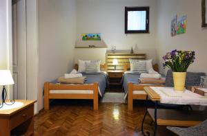 a room with two beds and a couch and flowers at Sobe Gajić Sremski Karlovci in Sremski Karlovci