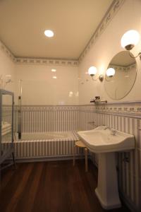 uma casa de banho com uma banheira, um lavatório e um espelho. em The Pine House em Peso da Régua