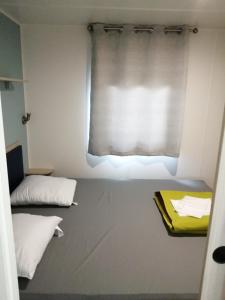 ein kleines Zimmer mit einem Fenster mit einem Vorhang in der Unterkunft Mobil-home (Clim)- Camping Narbonne-Plage 4* - 011 in Narbonne-Plage