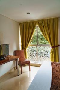 a room with a desk and a window with a chair at Hotel Boutique las Rosas 5 G in Medellín