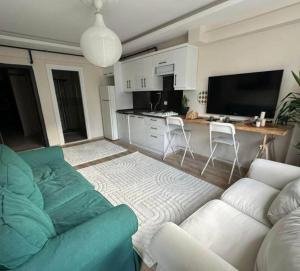 Il comprend un salon avec un canapé et une cuisine. dans l'établissement Nalyapan Apartmanı, à Konak
