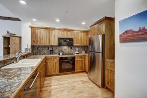 een keuken met houten kasten en een roestvrijstalen koelkast bij Elkhorn 408 in Beaver Creek