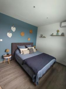 - une chambre avec un lit et un mur bleu dans l'établissement VILLA BELLE VUE, à Saint-Louis