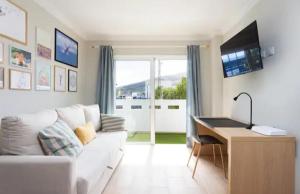 a living room with a white couch and a desk at Calma del mar in Santa Cruz de Tenerife