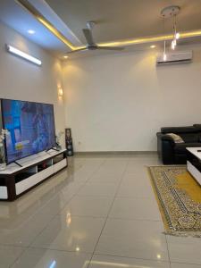 uma sala de estar com uma televisão de ecrã plano e um sofá em Villadeluxe1 em Cotonou