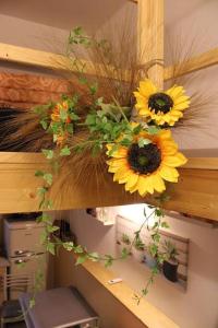a bunch of sunflowers on a wooden shelf at 4 posti letto vicino pala alpitour! in Turin