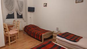um quarto com uma cama, uma cadeira e uma janela em Dom Wczasowy Skałka em Żabnica