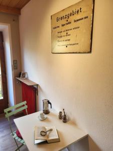 a table with a tea kettle and a book on it at Zum Bahngarten 1907 in Soprabolzano