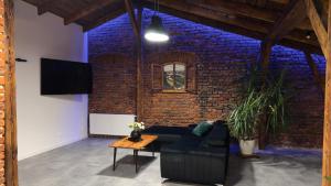 salon z kanapą i ceglaną ścianą w obiekcie Parkcity Katowice Bogucice w mieście Katowice