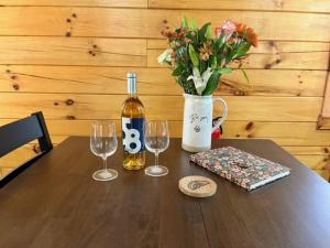 einen Tisch mit zwei Gläsern, eine Flasche Wein und Blumen in der Unterkunft The Heartwood in Hamden