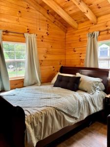ein Schlafzimmer mit einem Bett in einer Holzhütte in der Unterkunft The Heartwood in Hamden