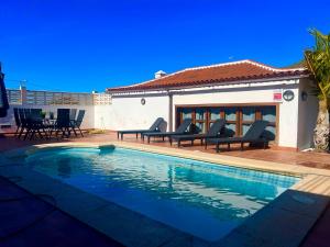 uma villa com uma piscina e mobiliário de pátio em Villa tegueste em Tegueste