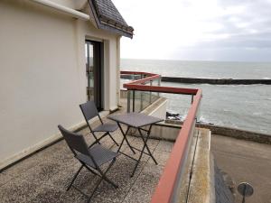 2 Stühle und ein Tisch auf dem Balkon mit Meerblick in der Unterkunft Panorama & Océan - Les Gîtes de la Côte d'Amour in Batz-sur-Mer